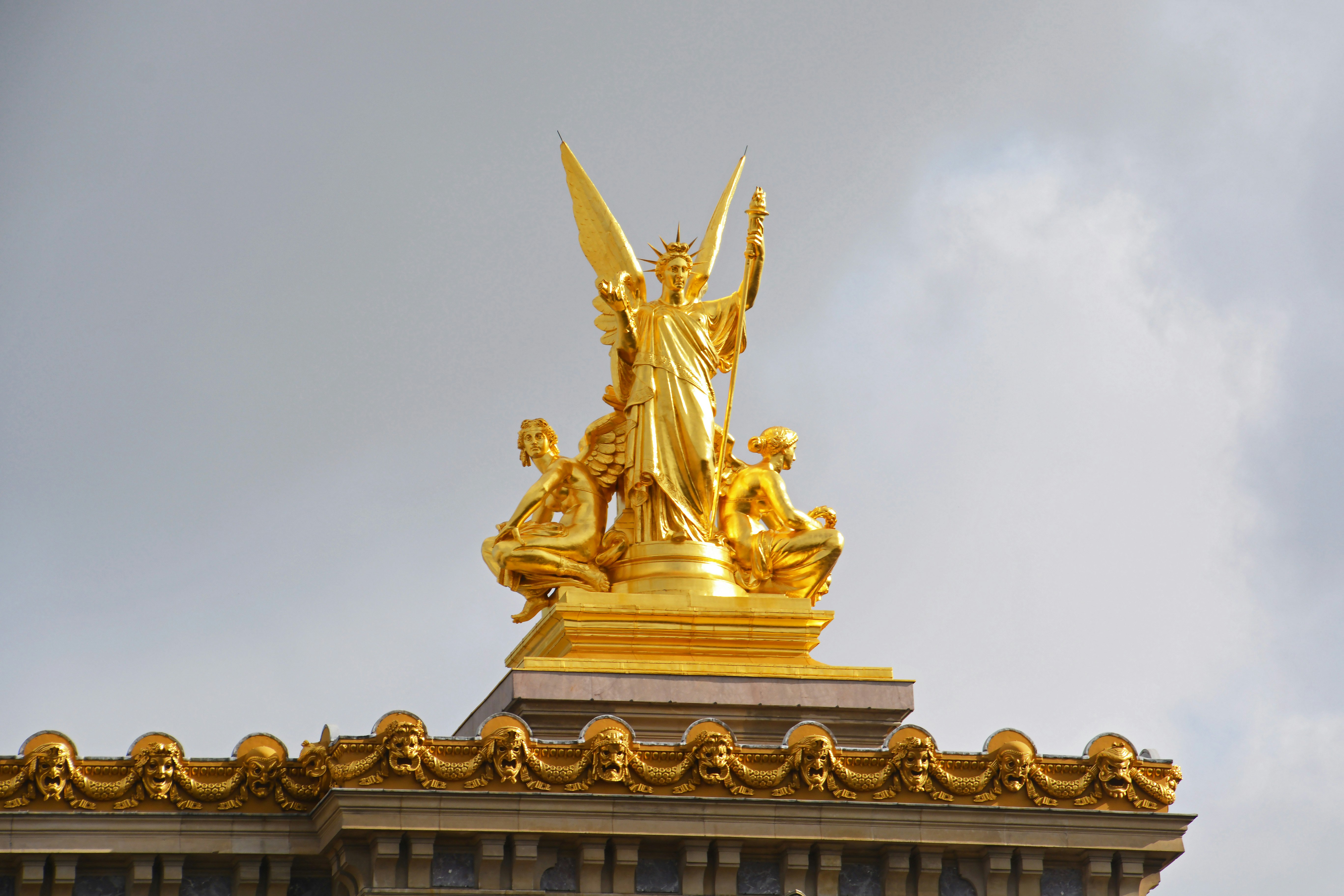 gold statue under white sky during daytime